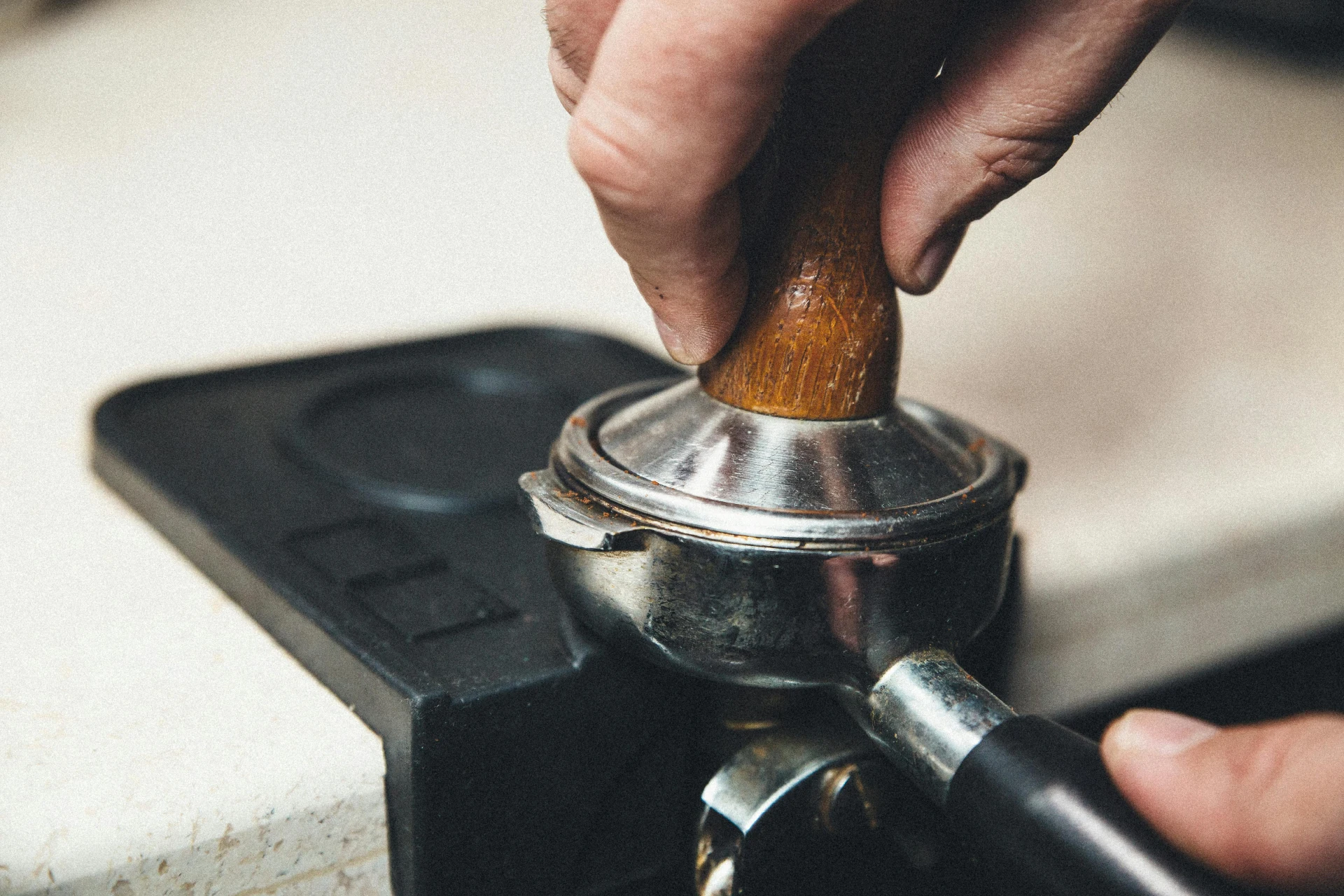 Barista beim Tampen von Kaffee in Nahaufnahme zur genauen Anleitung