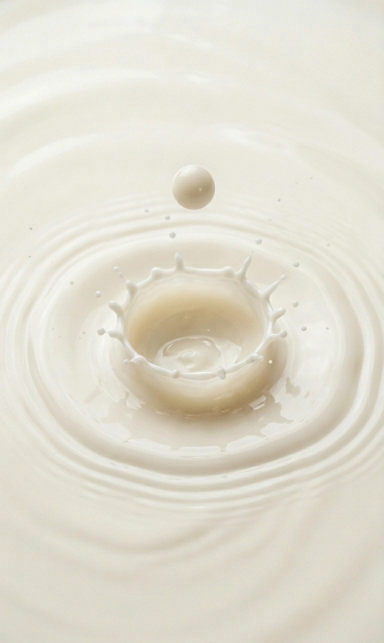 Nahaufnahme eines Milchtropfens, der eine Kronenform in cremig-weißer pflanzlicher Milch erzeugt