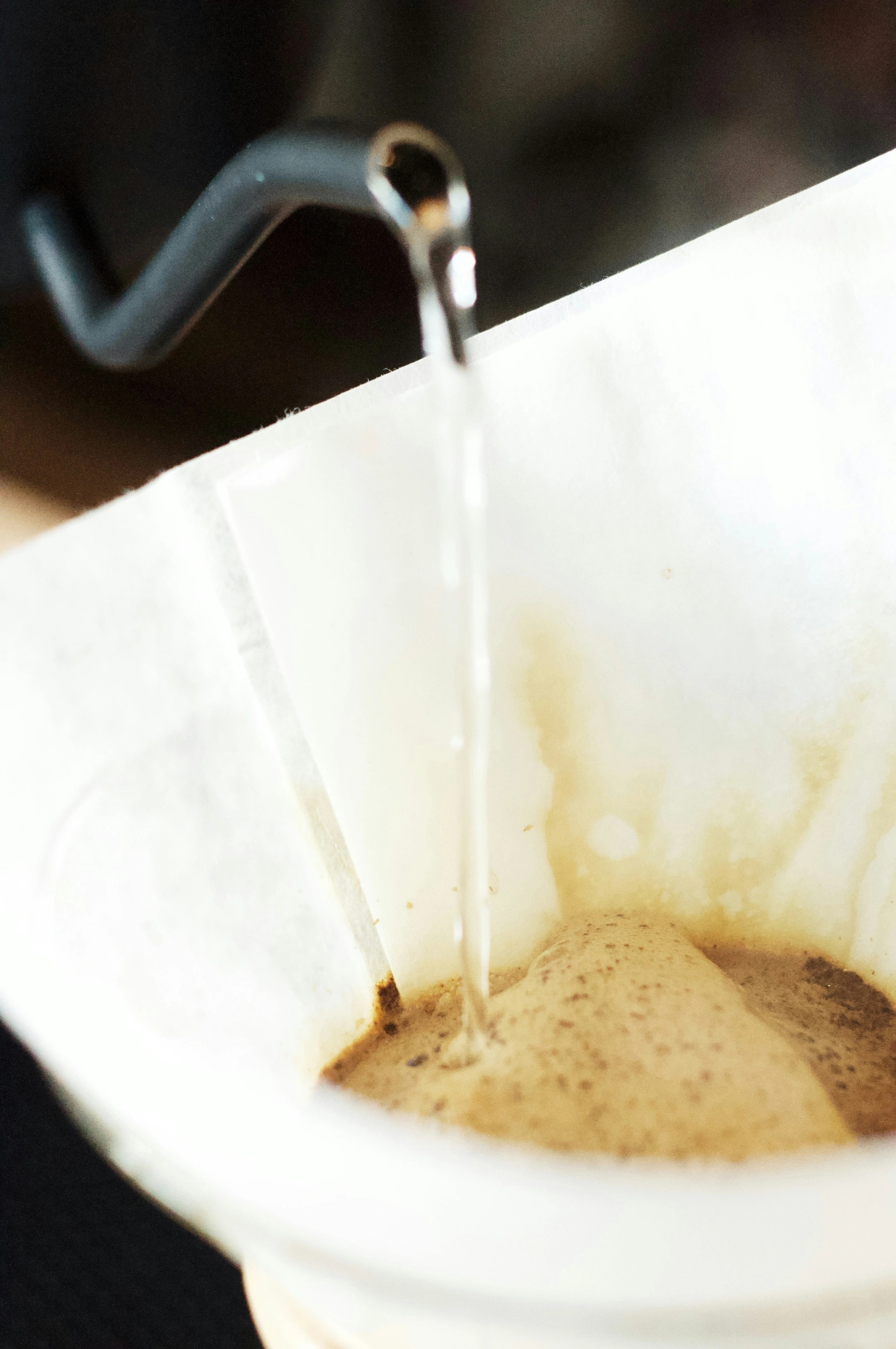 Nahaufnahme von kochendem Wasser beim eingießen in Kaffeefilter