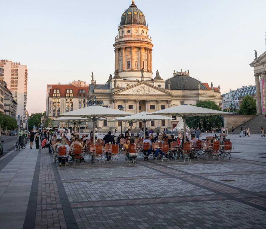 Innenstadt vor dem französischen Dom mit vielen Tischen und Stühlen von einem Café zum entspannen im Sommer