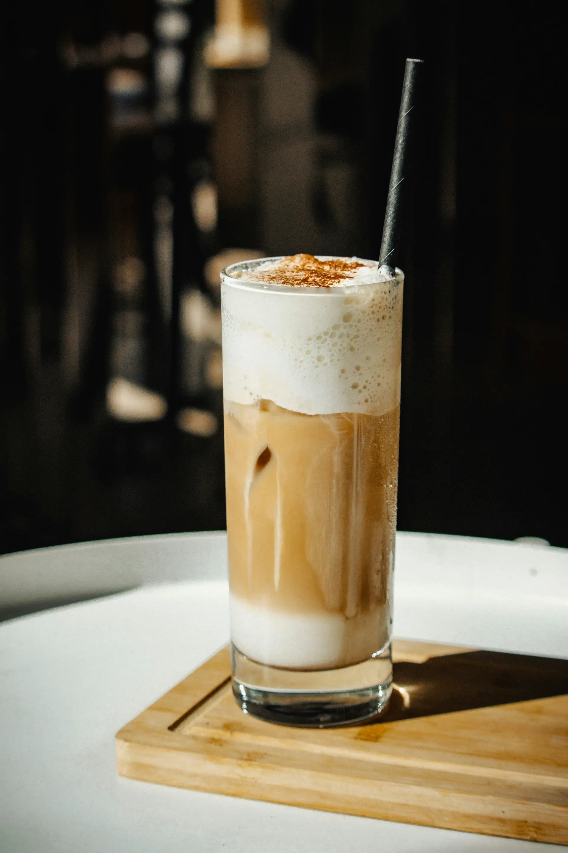Kaffee Latte in hohem Glas mit Strohhalm