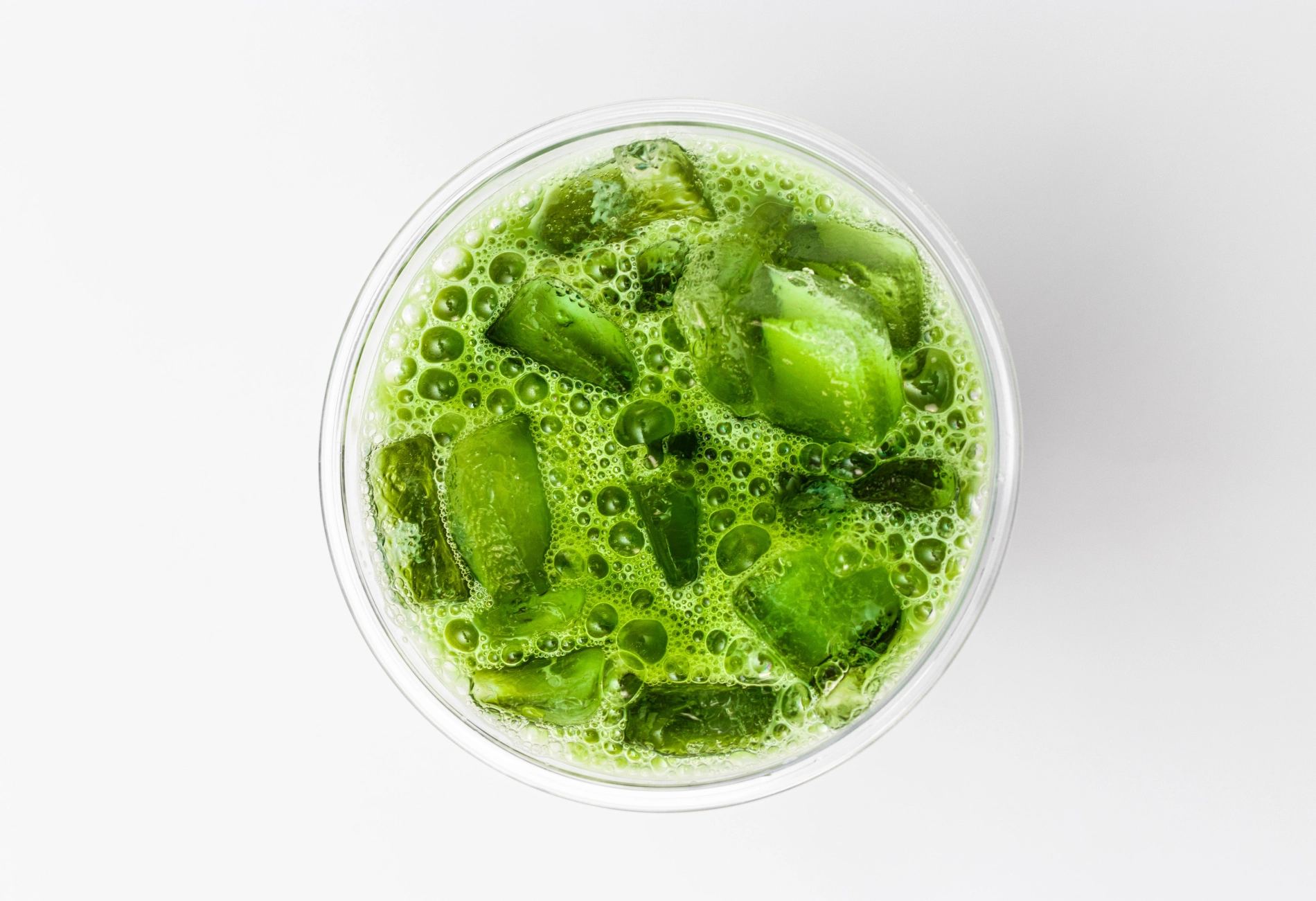 Matcha Soda im Glas mit Sprudelwasser und Eiswürfeln